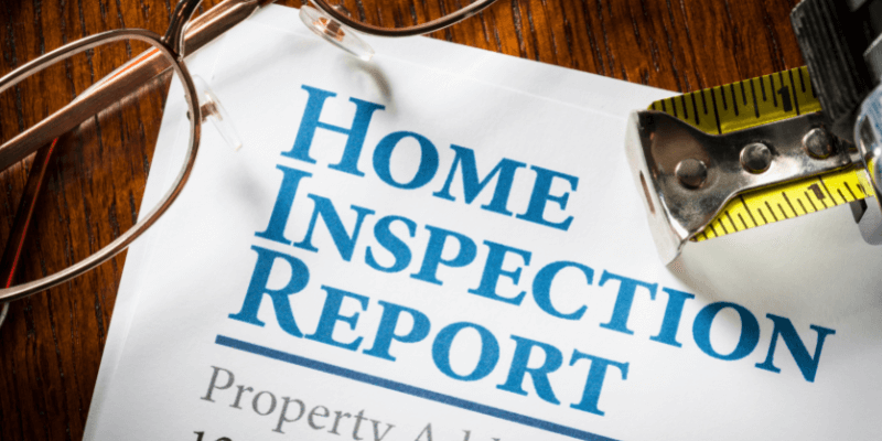 Home Inspection Report A printed home inspection report with glasses and a tape measurer.