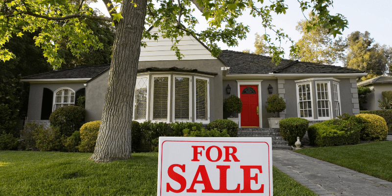 What happens when a buyer backs out? Gray house with red door has a For Sale sign in the front yard.