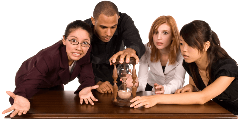 When is it too late to back out? Four worried looking people focused on and touching an hour glass with time running out.